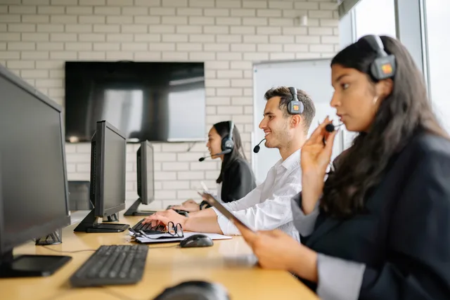 Diverse group of call center agents working together in a modern office environment. Alternative di connettività e telefonia per le imprese: fibra, FWA e VoIP